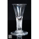 An 18th Century glass drinking glass, circa 1750, the trumpet bowl with solid base over a multiple