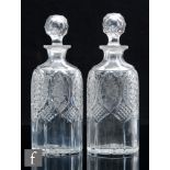 A pair of 19th Century clear crystal glass spirit decanters of compressed sleeve form, the body