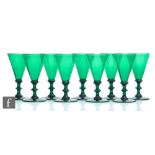 A set of nine 19th Century drinking glasses in deep green, the conical bowl above an annulated