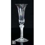 An 18th Century drinking glass, circa 1755, the slender flared round funnel bowl above a short solid