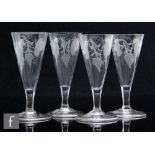 A group of four ale glasses, circa 1820, the conical bowls engraved with hops and barley, above a