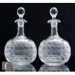 A pair of late 19th Century clear crystal glass spirit decanters of compressed globe and shaft form,