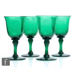 A set of four 19th Century Bristol green drinking glasses with bell form bowl with shoulder bladed