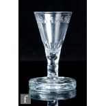 An 18th Century toasting drinking glass, circa 1785, the conical bowl with daisy border above a