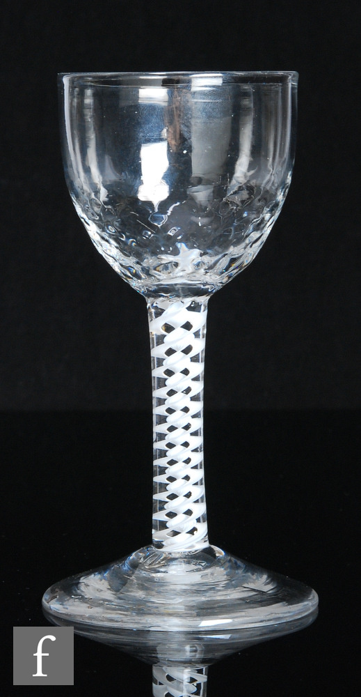 An 18th Century drinking glass, circa 1765, the planished ovoid bowl above a double series opaque