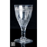 An 18th Century goblet, circa 1785, the large round funnel bowl engraved to the upper rim with a