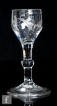 An 18th Century drinking glass, circa 1740, the ovoid bowl engraved with a bird in flight with a