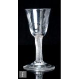 An 18th Century drinking glass, circa 1755, the round funnel bowl with basal moulding above an