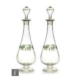 A pair of 1930s Czechoslovakian glass decanters, each of footed tapering form, the clear body enamel