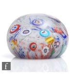 An antique Baccarat paperweight, scattered millefiori and Gridel silhouette canes on white muslin,