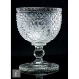 An early 19th Century glass pedestal bowl, circa 1800, the deep cup bowl with an oval cartouche