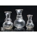 A small group of three 19th Century clear crystal graduated whiskey measures, each of varying