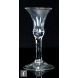 An 18th Century drinking glass circa 1740, the waisted bell form bowl with basal air bubble tear