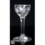 An 18th Century drinking glass, circa 1750, the cup bowl engraved with a bird in flight with a