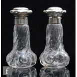 A pair of early 20th Century rock crystal style perfume bottles, possibly Stevens & Williams, of low