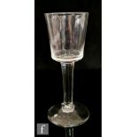 An 18th Century drinking glass circa 1740, the bucket form bowl above a plain stem, raised to a