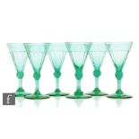 A set of six 19th Century green wine glasses, the slice cut conical bowl above a facet knop and