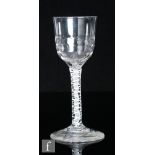 An 18th Century drinking glass, circa 1765, the planished ogee bowl over a double series opaque
