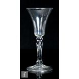 An 18th Century light baluster drinking glass circa 1750, the flared round funnel bowl above a