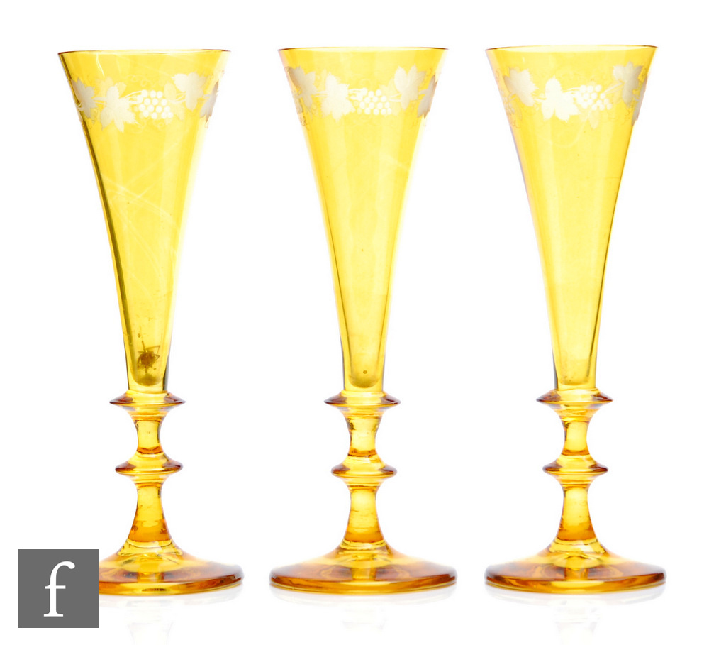 A set of three 19th Century Bohemian champagne flutes of flared trumpet form raised to a double