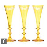 A set of three 19th Century Bohemian champagne flutes of flared trumpet form raised to a double