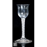 An 18th Century drinking glass, circa 1765, the waisted ogee bowl above a single series opaque twist