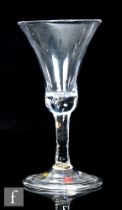 An 18th Century drinking glass, circa 1750, the flared waisted bell form bowl above a slender