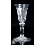 An 18th Century drinking glass with a drawn round funnel bowl with vertical moulding above a