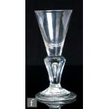 An early 18th Century moulded pedestal stem drinking glass, circa 1710 to 1720, the funnel bowl with