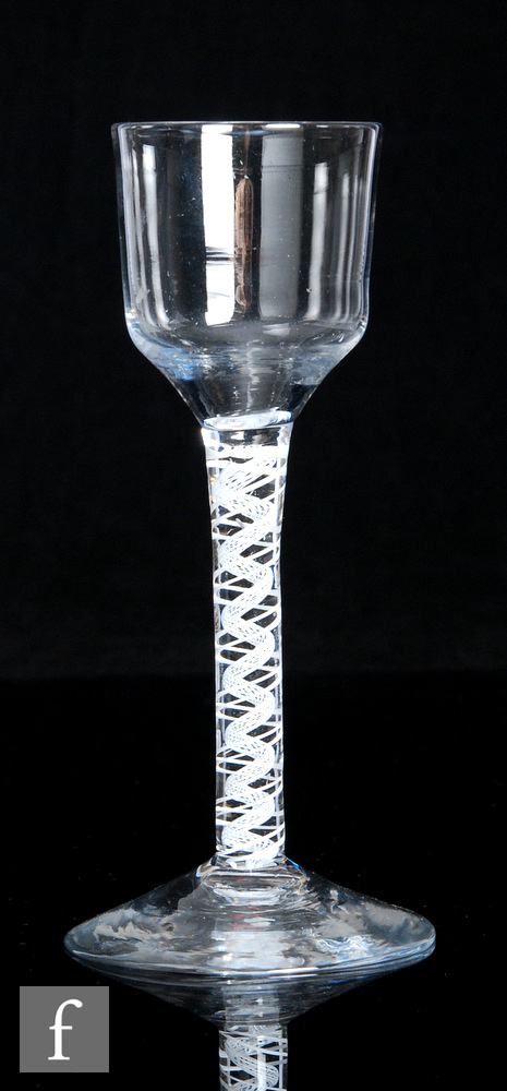 An 18th Century drinking glass circa 1765, the ogee form bowl above an opaque twist stem with two