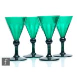 A set of four 19th Century Bristol green drinking glasses with basal cut conical bowl above a
