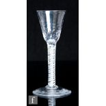 An 18th Century drinking glass, circa 1770, the funnel with basal moulded flutes and spots above a