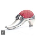 An Edwardian hallmarked silver pin cushion modelled as a shoe with buckle detail and red cushion,