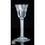 An 18th Century drinking glass, circa 1750, the round funnel bowl engraved with a band of fruiting