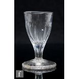 An 19th Century drinking glass, circa 1750, the fluted round funnel bowl falling to an integral