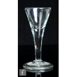 An 18th Century drinking glass, circa 1740, the drawn trumpet bowl above a plain stem and raised