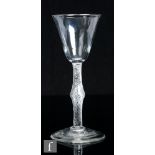 An 18th Century drinking glass, circa 1755, the pointed round funnel bowl over a multiple spiral air