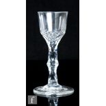 An 18th Century drinking glass, circa 1785, the ogee bowl with basal fleur de leys cuts above a