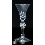 An 18th Century composite drinking glass circa 1750, the slender pointed round funnel bowl with