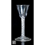 An 18th Century drinking glass, circa 1765, the pointed round funnel bowl above a double series