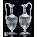 A pair of 19th Century Stourbridge clear crystal ewers, each of classical shouldered ovoid form with