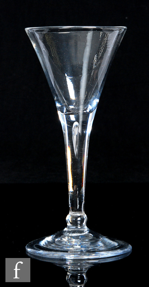 An 18th Century drinking glass, circa 1750, the flared trumpet bowl above an integral plain stem