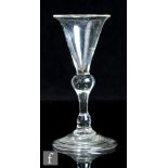 A small 18th Century balustriod drinking glass, circa 1750, the flared conical bowl above a large