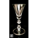 An 18th Century drinking glass circa 1750, the bell bowl above a drop knop and inverted baluster