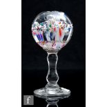 A 19th Century wig or desk stand with spherical paperweight top with internal decoration raised to a