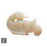 A Chinese Qing Dynasty (1644-1912) 'Duck' carving, depicted swimming with head turned, the pale