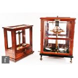 An early 20th Century mahogany cased set of balance scales by Oertling with glass flask accessories,