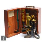 An early 20th Century brass and black painted microscope by Swift & Son London, with spare lenses,