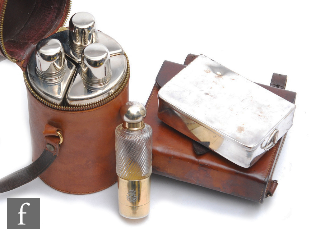 An early 20th Century three divisioned glass bottle cologne set with plated tops in brown leather