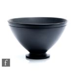 A 1930s Art Deco Keith Murray for Wedgwood black basalt bowl of footed conical form with a carved